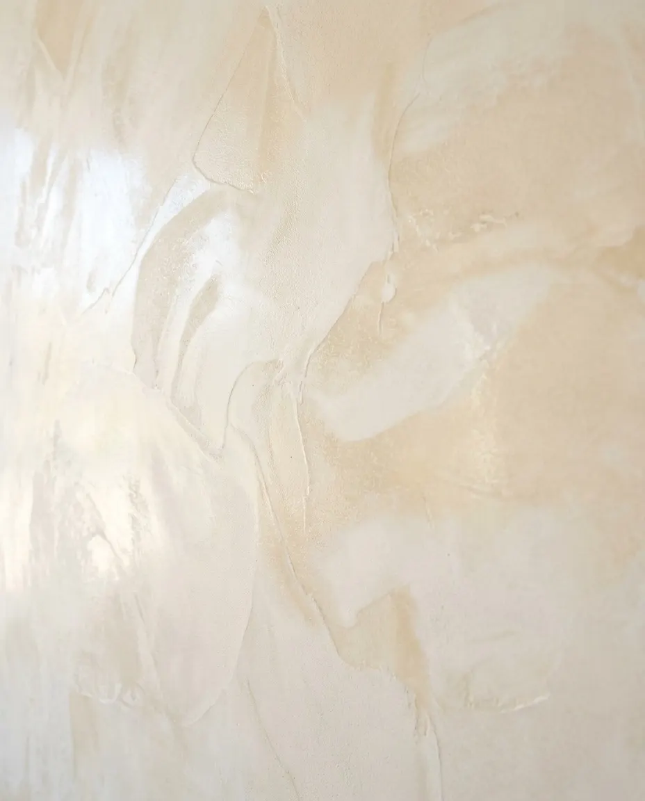 Pormenor de estuque marmorino em creme e marfim, com a luz a deslizar.